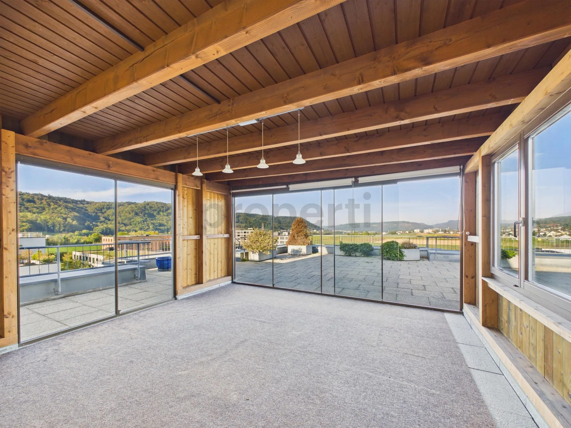 4.5/5.5 Zimmer Wohnung mit privater 120 m² Dachterrasse mit verglastem Pavillon, Cheminée, Süd-Balkon & Tiefgaragenplatz!