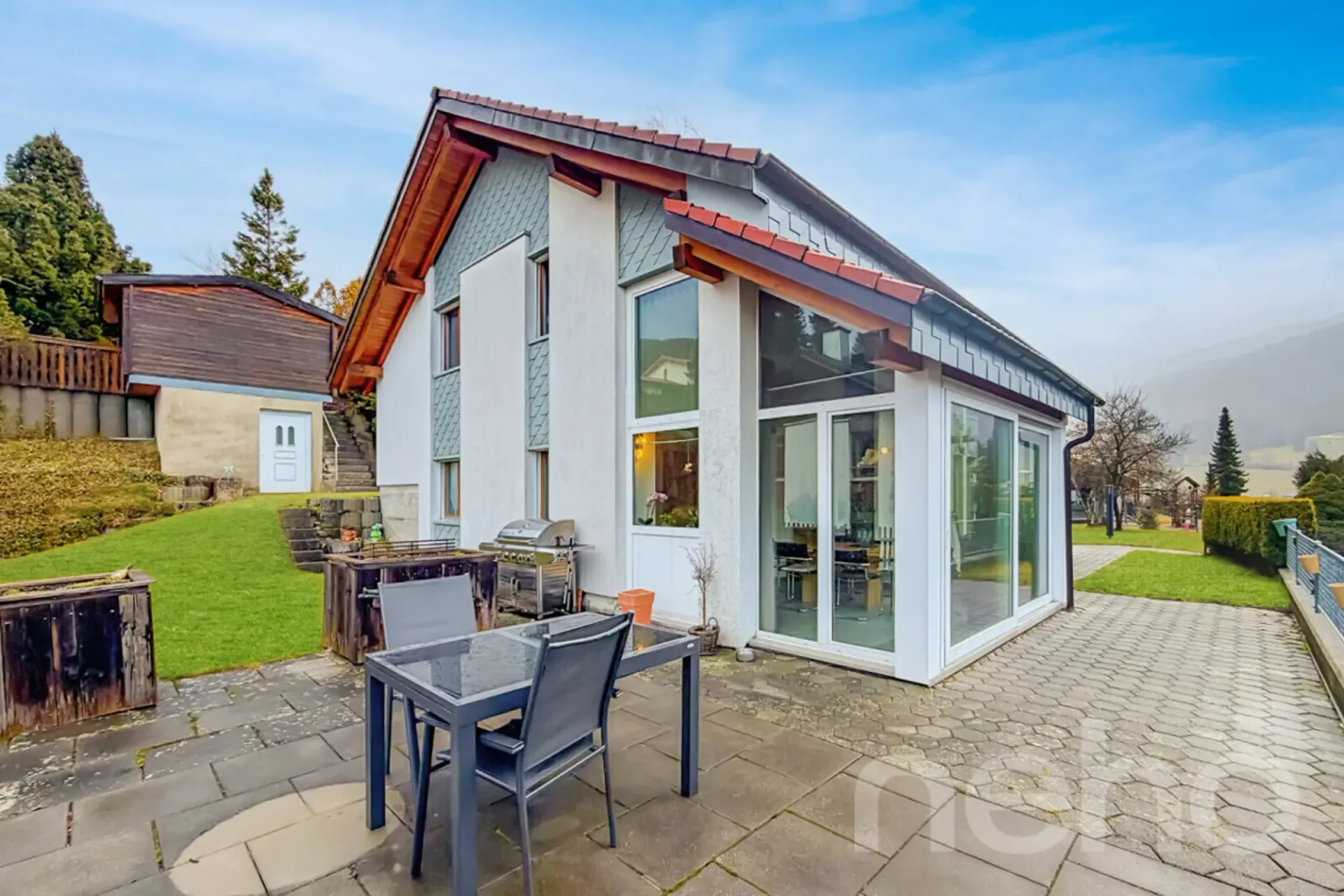 Eine Villa, die in Licht gebadet ist und zwischen Himmel und Bergen schwebt