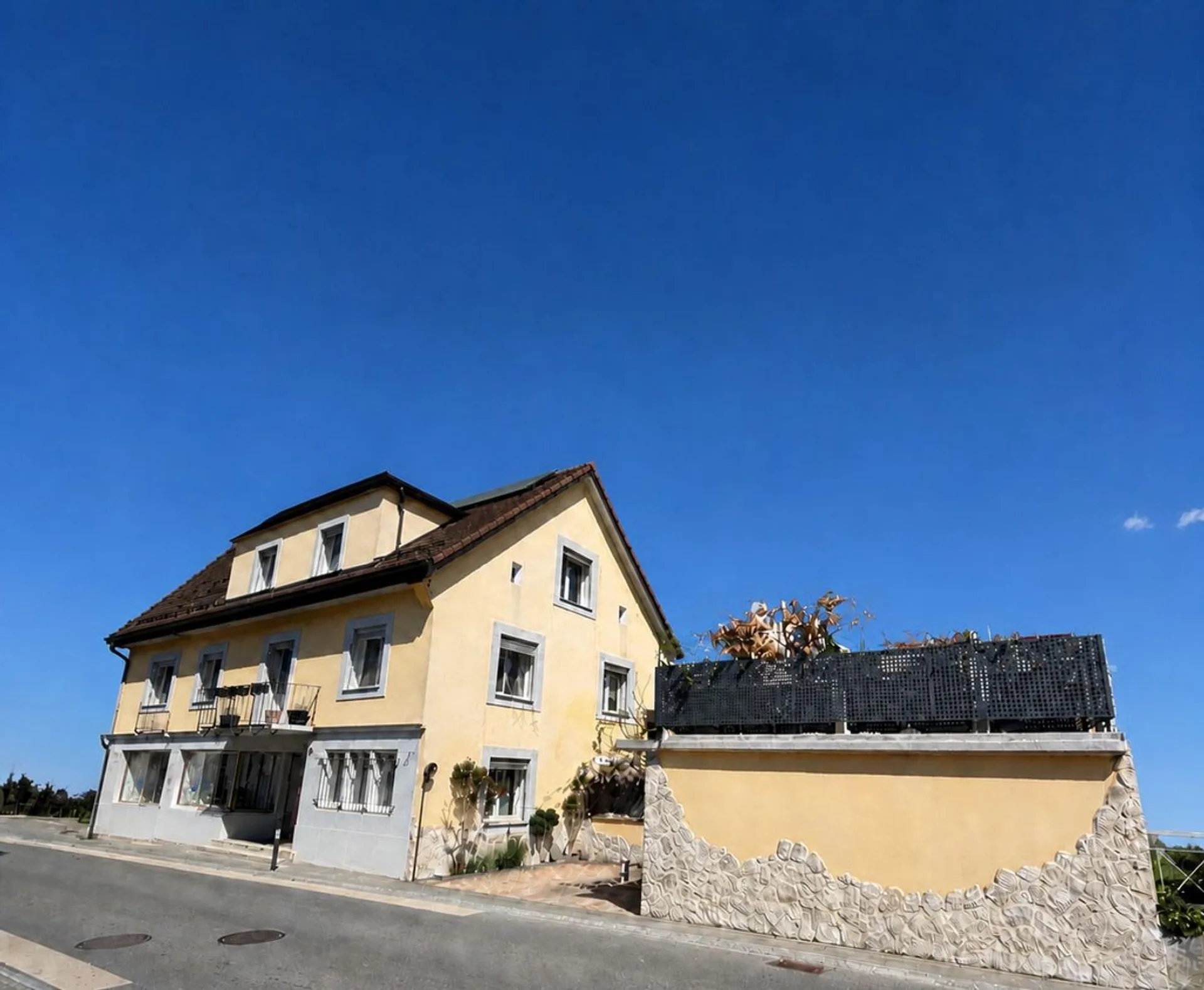 Gebäude mit 2 Wohnungen, einem Gewerberaum - 2 Schlafzimmern - 2 Parkplätzen und einer Garage/Terrasse im Zentrum des Dorfes
