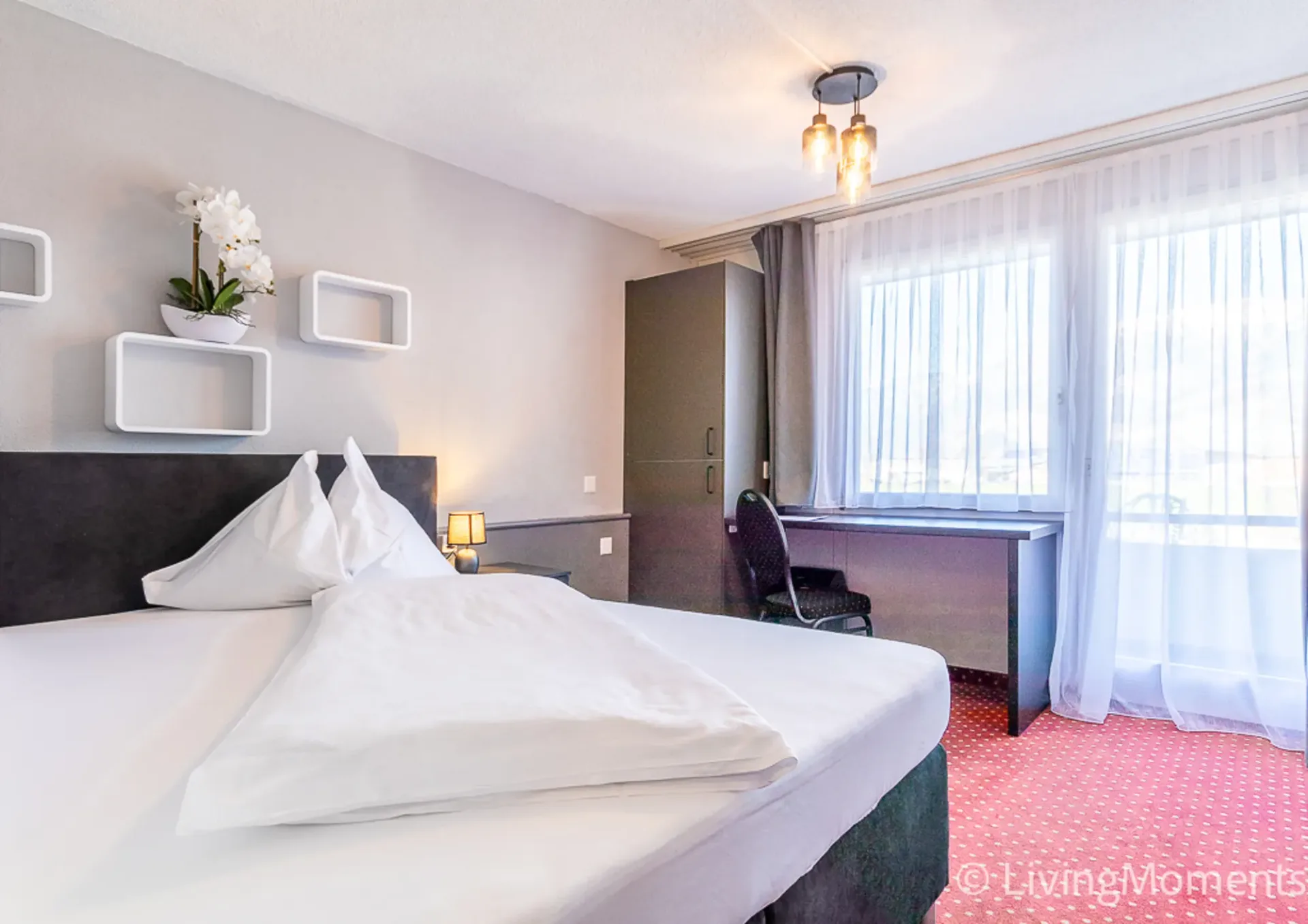 Stilvoll eingerichtetes Studio mit Boxspringbett und eigenem Balkon